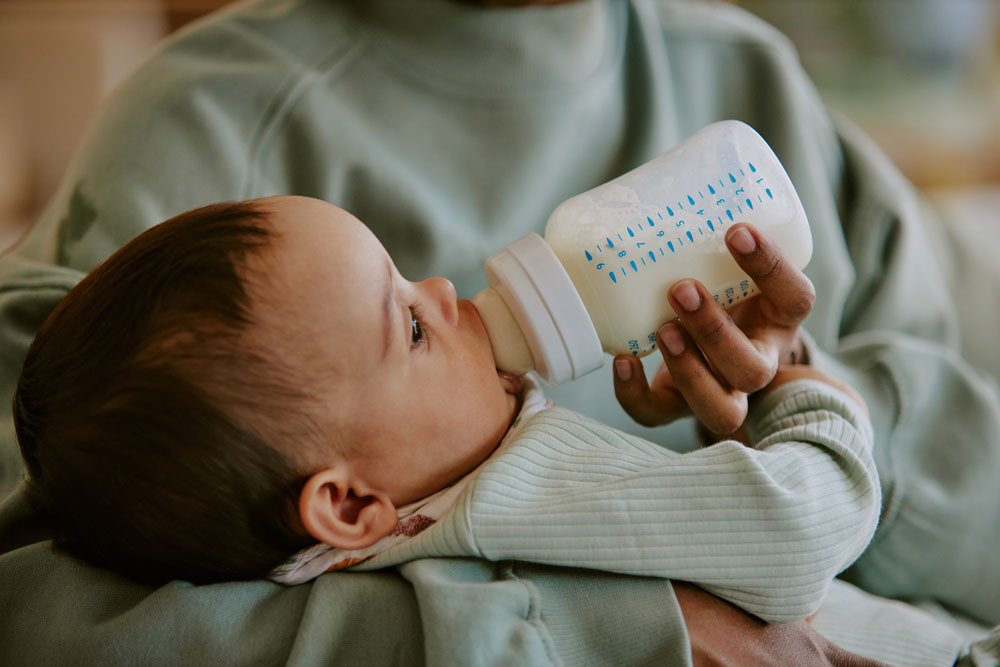 an infant drinking a bottle of formula