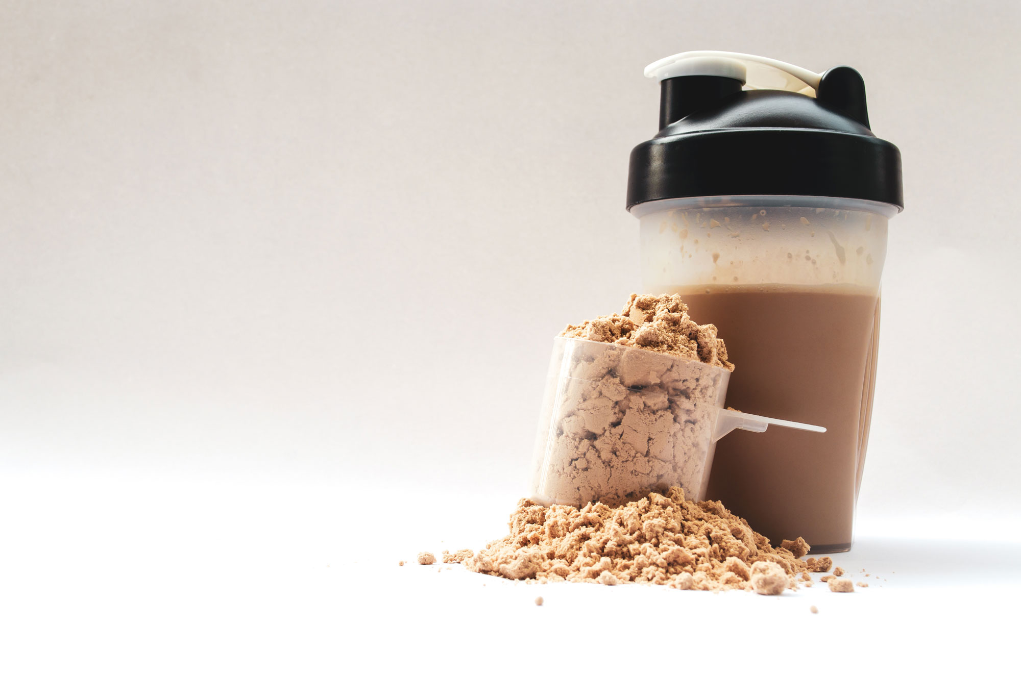 a protein shake with a scoop of protein powder in the foreground